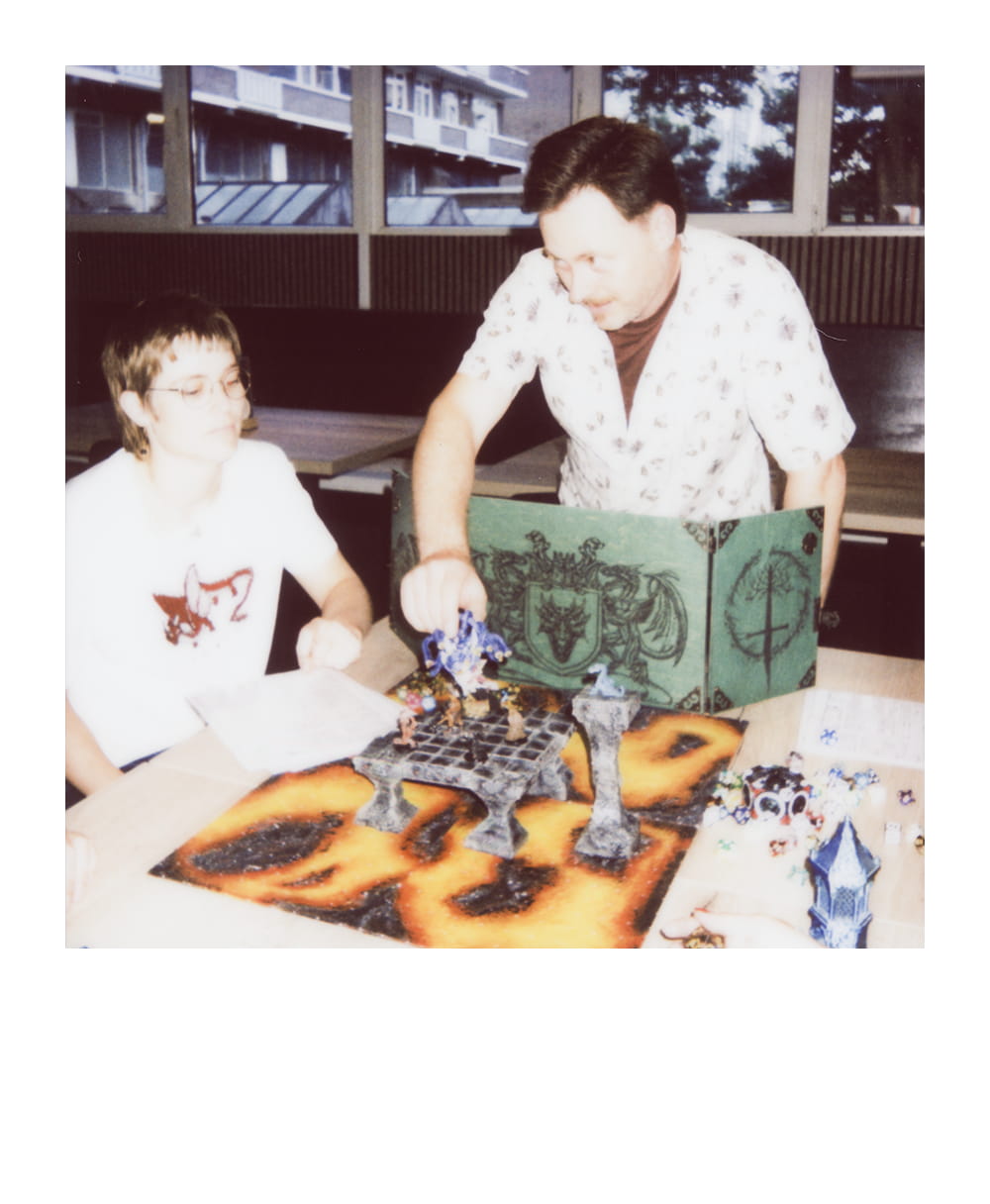 Game Master moves a large miniature across a lava-themed battle map during a fantasy roleplaying encounter.